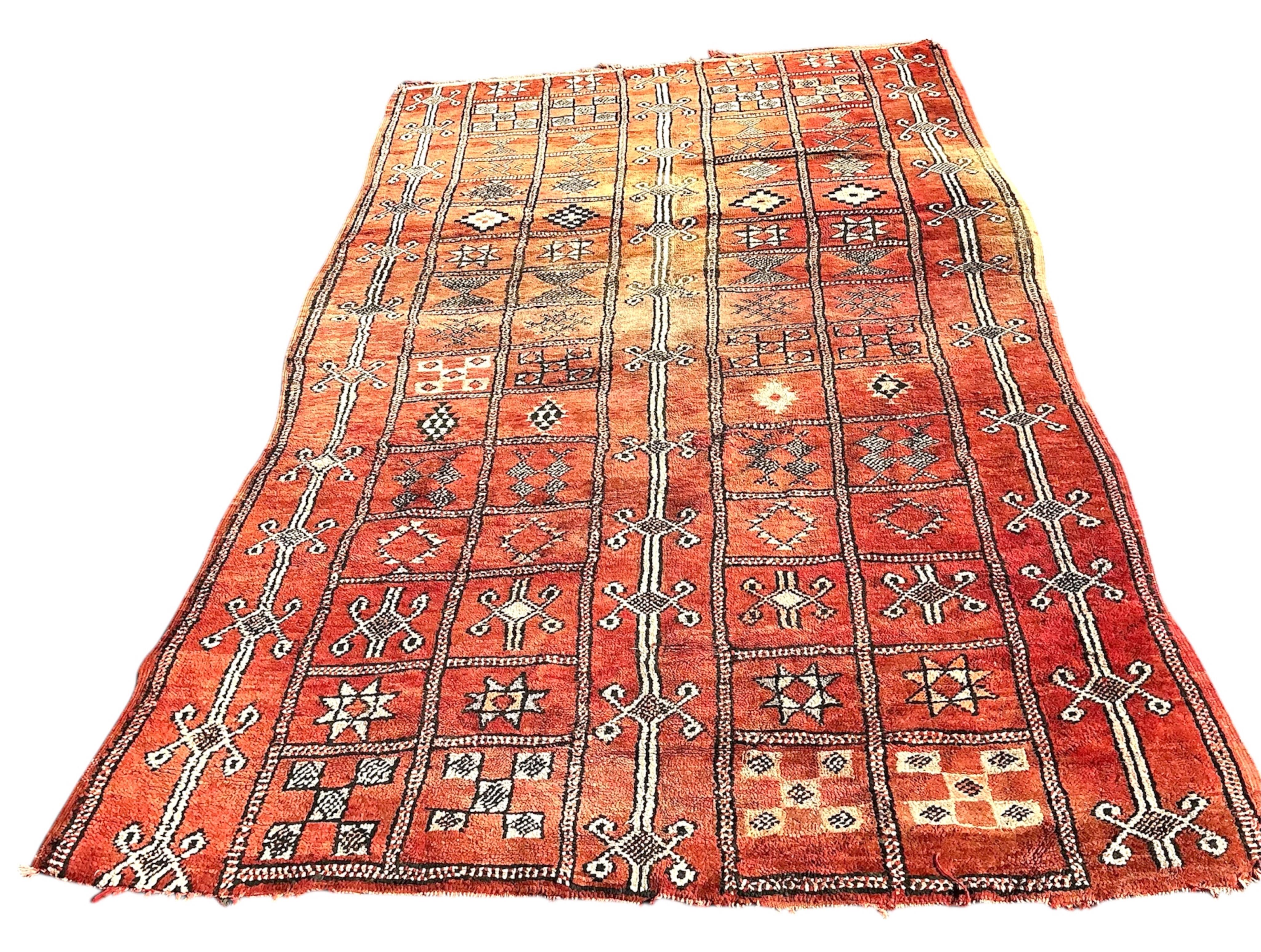 A Moroccan Berber pale red ground carpet, 300 x 190cm